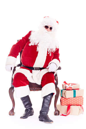 Portrait of swaggy Santa Claus in sunglasses relaxing in chair on white backgroundの写真素材