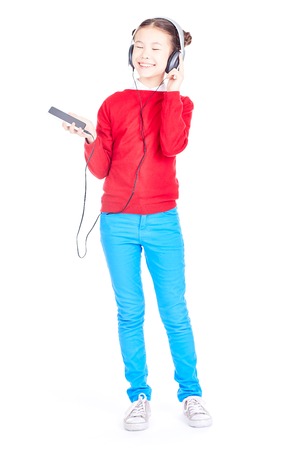 Portrait of Asian girl listening to music on her smartphone through headphonesの写真素材