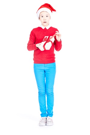 Asian girl in Santa hat holding Christmas gift isolated on whiteの写真素材