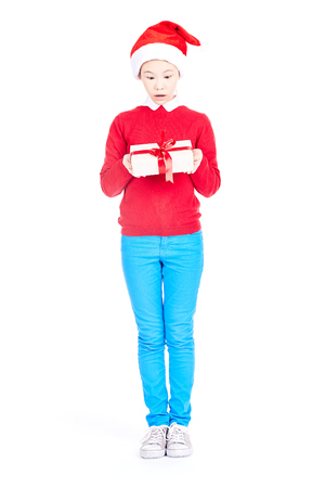 Asian girl in Santa hat holding Christmas gift isolated on whiteの写真素材