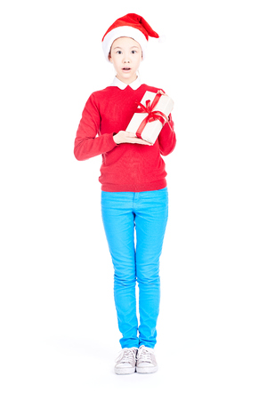 Asian girl in Santa hat holding Christmas gift isolated on whiteの写真素材