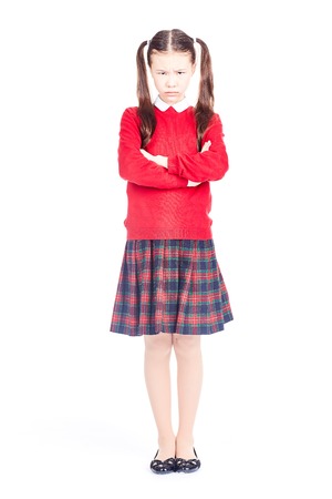 Asian female elementary student in school uniform posing on white backgroundの写真素材