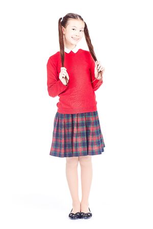 Asian female elementary student in school uniform posing on white backgroundの写真素材