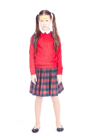 Asian female elementary student in school uniform posing on white backgroundの写真素材