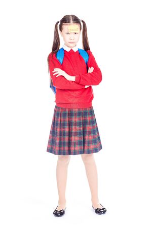 Asian female elementary student in school uniform posing on white backgroundの写真素材