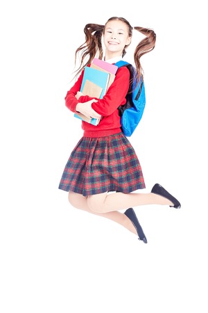 Portrait of female elementary student in school uniform holding notebooks and textbooksの写真素材
