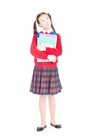 Portrait of female elementary student in school uniform holding notebooks and textbooksの写真素材