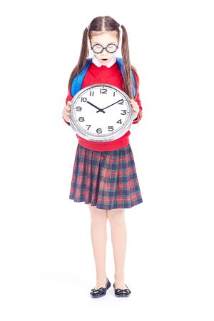 Portrait of Asian girl in school uniform holding clock on white backgroundの写真素材