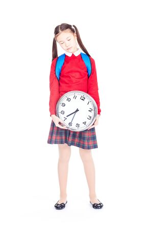 Portrait of Asian girl in school uniform holding clock on white backgroundの写真素材