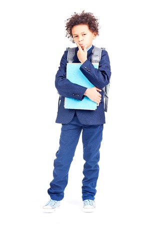 Portrait of cute mixed race boy with curly hair wearing school uniformの写真素材