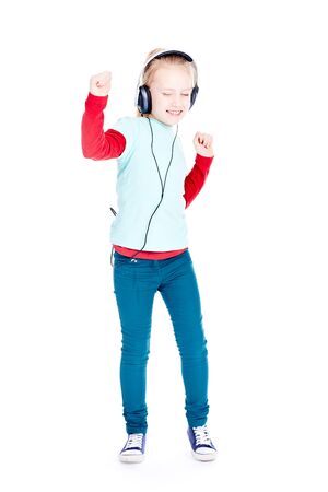 Portrait of little girl with earphones enjoying listening to musicの写真素材