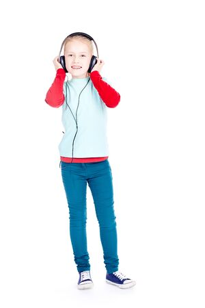 Portrait of little girl with earphones enjoying listening to musicの写真素材