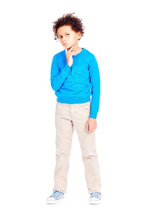 Portrait of cute curly-haired Latin American boy posing on white backgroundの写真素材