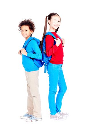 Portrait of Asian schoolgirl and Latin American schoolboy posing together on white backgroundの写真素材