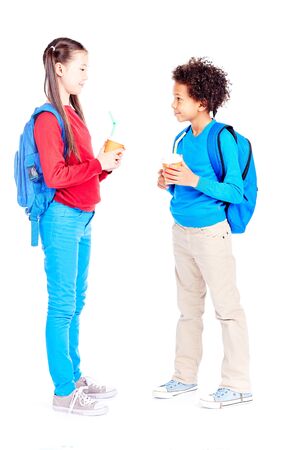 Portrait of Asian schoolgirl and Latin American schoolboy posing together on white backgroundの写真素材