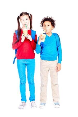 Portrait of Asian schoolgirl and Latin American schoolboy posing together on white backgroundの写真素材