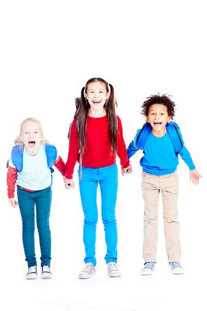 Portrait of three multi-ethnic school friends holding hands on white backgroundの写真素材
