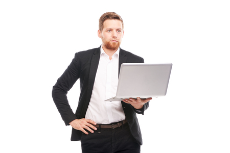 Studio portrait of young manager in suit holding open laptopの写真素材