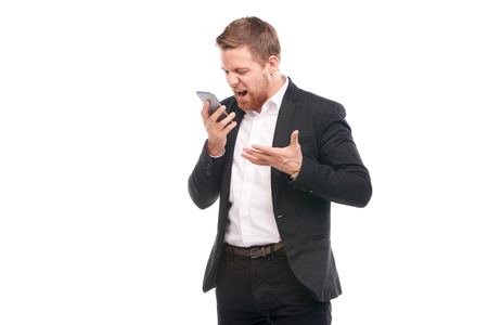Portrait of young businessman with mobile phone on white backgroundの写真素材