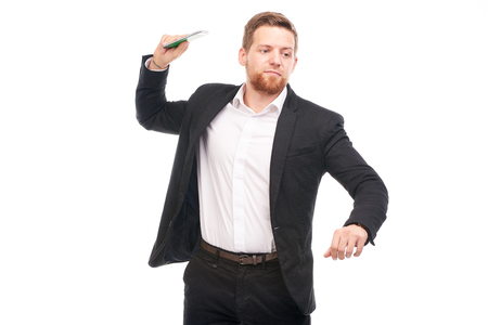Portrait of young businessman with mobile phone on white backgroundの写真素材