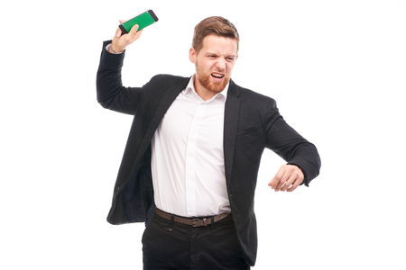 Portrait of young businessman with mobile phone on white backgroundの写真素材