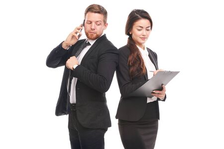 Portrait of Caucasian businessman and Asian businesswoman cooperatingの写真素材