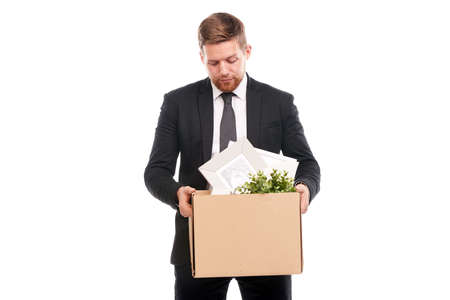 Office worker in suit holding box with personal belongings on white backgroundの写真素材
