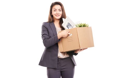 Portrait of young businesswoman holding box with personal belongingsの写真素材