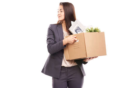 Portrait of young businesswoman holding box with personal belongingsの写真素材