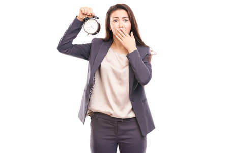 Young businesswoman holding alarm clock isolated on whiteの写真素材