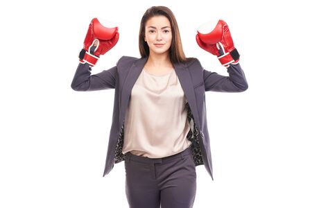 Portrait of beautiful young businesswoman wearing red boxing glovesの写真素材