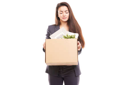 Portrait of young businesswoman holding box with personal belongingsの写真素材