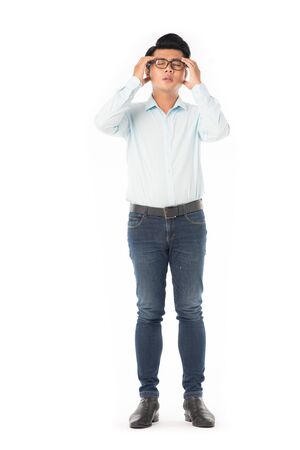 Full length portrait of young Asian man suffering from headache isolated on whiteの写真素材