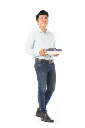 Studio portrait of young Asian man holding gift boxの写真素材