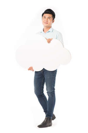 Young Asian man holding blank thought cloud isolated on whiteの写真素材