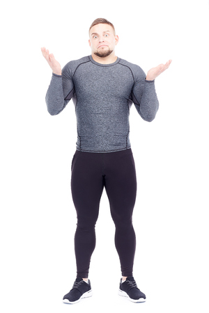 Portrait of handsome well-muscled gym instructor in sports tights and rashguard posing on white backgroundの写真素材