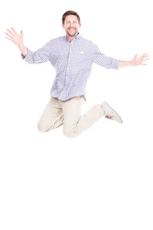 Vertical full length studio shot of joyful Caucasian man with beard on face wearing casual outfit jumping, white backgroundの写真素材