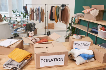 No people shot of modern clothes charity organization room full of various clothing and package boxesの写真素材