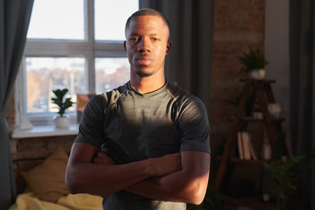Horizontal medium portrait of modern African American man wearing sportswear in sunlight