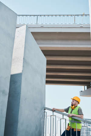 Wide angle shot of construction site with crew workers holding plans and discussing project, copy spaceの写真素材