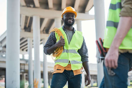 Two workers standing on concrete floor of construction site and discussing projectの写真素材
