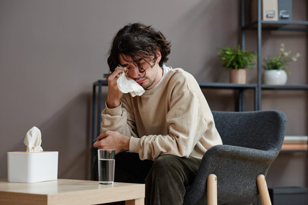Horizontal medium portrait of despaired young Caucasian man suffering stress having psychologist...