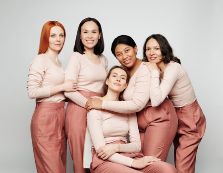 Group photo of diverse attractive real ladies with different skins posing together against isolated backgroundの写真素材