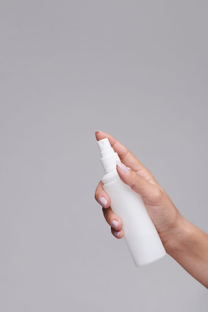 Close-up of unrecognizable woman using sanitizer to clean hands during coronavirus pandemic,...