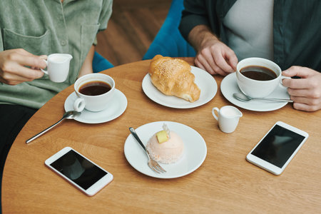photo of black coffee and croissant on table in cafe, bloggers lifestyle concept