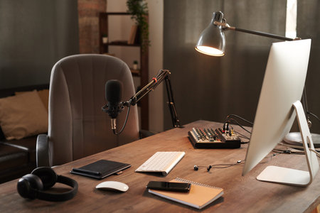 No people shot of modern vloggers workplace interior in loft room with computer, microphone and headphones on wooden tableの写真素材