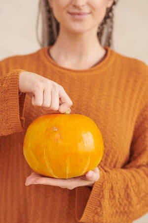 Portrait of smilingyoung woman with white dreads posing with pumpkin against isolated background, Halloween conceptの写真素材