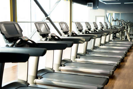Fitness club with row of treadmills for fitness cardio exercisesの写真素材