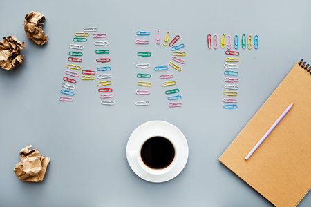 High angle view of creative workplace with crunched paper, cup of black coffee, notepad and pencil,...
