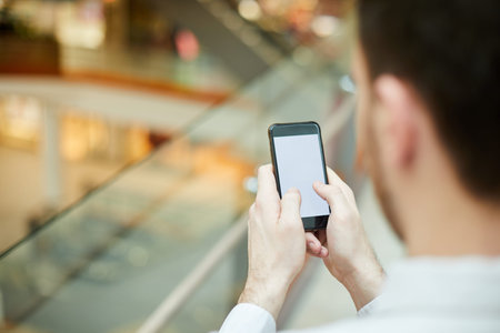 Close-up of unrecognizable businessman texting sms on gadget or searching for information on...